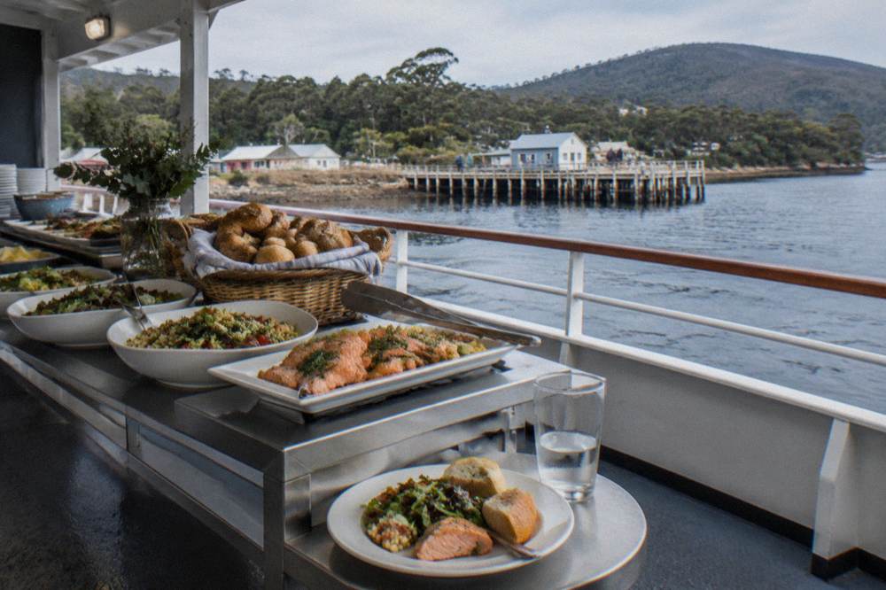 Buffet lunch dishes with Tasmanian produce laid out on a cruise vessel table