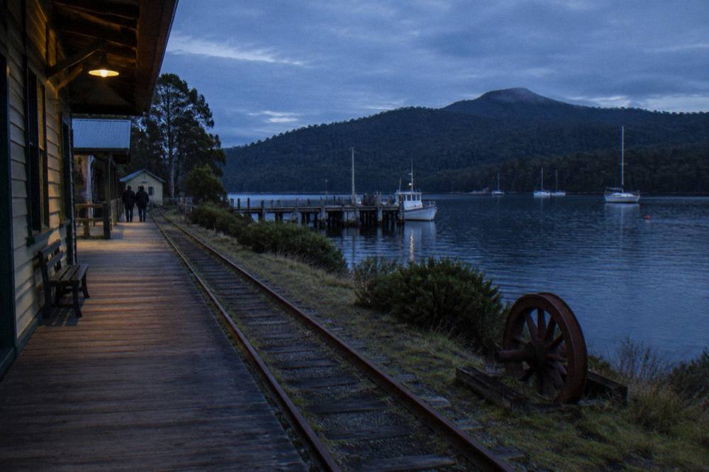 Strahan Esplanade waterfront at dusk with boats moored on Macquarie Harbour