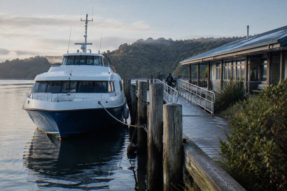A cruise boat tied at the Strahan wharf on the Esplanade in early morning light