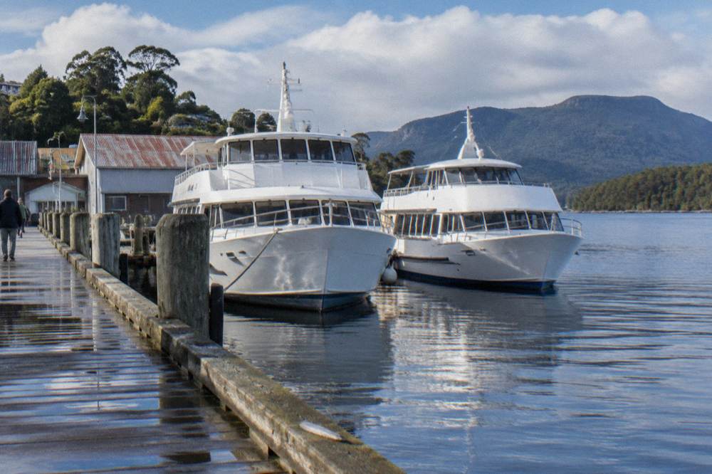 Two cruise vessels moored along the Strahan Esplanade wharf